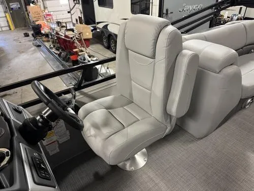 Slide: The Image of 2025 Regency 230 DL3 boat interior with plush seating and steering wheel. - 10