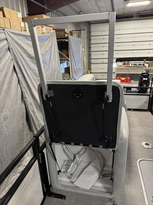 Slide: The Image of 2025 Regency 230 DL3 boat interior with adjustable seat mechanism in a storage facility. - 12