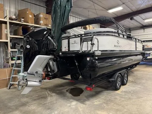 Slide: The Image of 2025 Regency 230 DL3 pontoon boat in a warehouse, featuring a powerful outboard motor. - 3