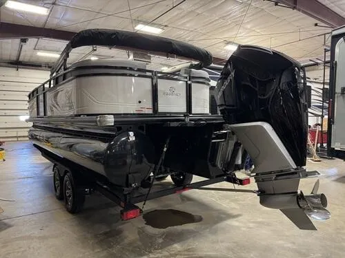 Slide: The Image of 2025 Regency 230 DL3 pontoon boat in a warehouse, featuring a powerful outboard motor. - 4