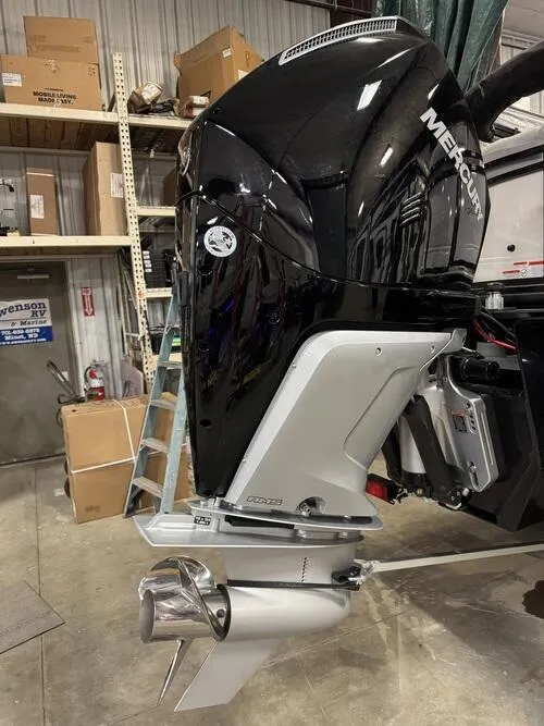 Slide: The Image of Outboard motor on a 2025 Regency 230 DL3 boat in a workshop setting. - 5