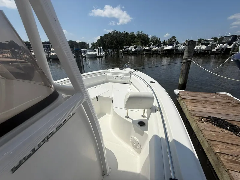 Slide: The Image of 2017 Sea Hunt Ultra 234 boat docked at marina under clear blue sky. - 18