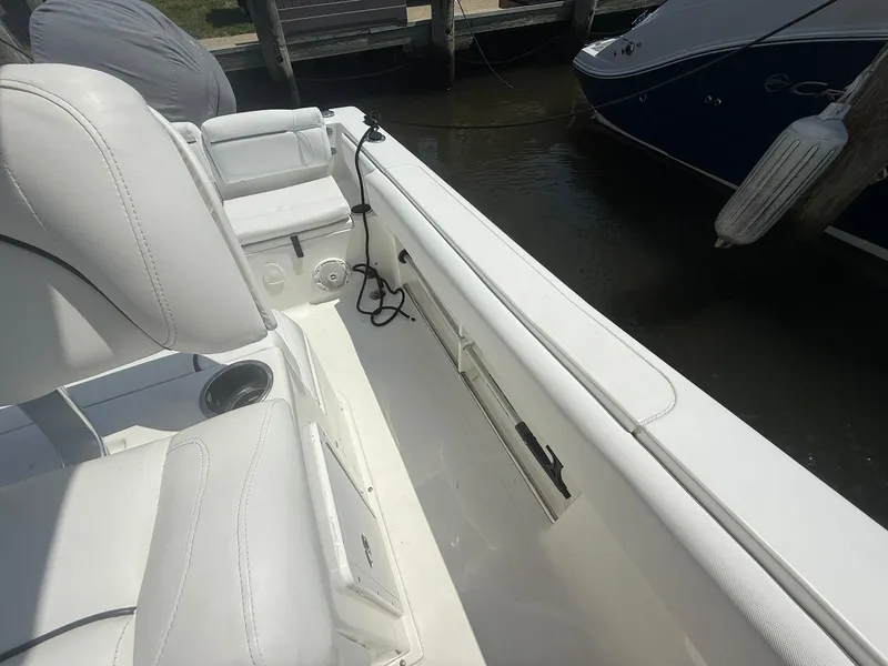 Slide: The Image of 2017 Sea Hunt Ultra 234 boat interior with white seating and cup holder. - 21