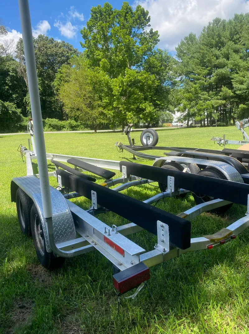 Slide: The Image of Trailer for 2017 Sea Hunt Ultra 234 boat on grassy field. - 24