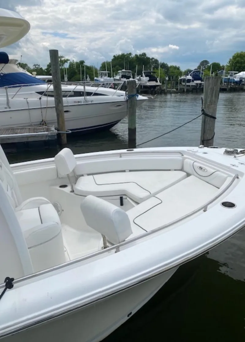 Slide: The Image of 2017 Sea Hunt Ultra 234 boat docked at marina, featuring spacious seating and sleek design. - 25