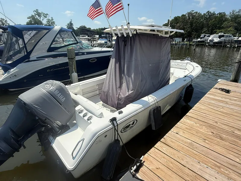 Slide: The Image of 2017 Sea Hunt Ultra 234 boat docked with Yamaha outboard motor and American flags. - 3