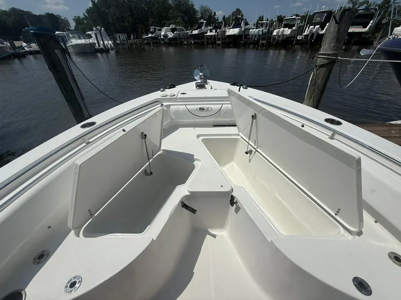 Slide: The Image of 2017 Sea Hunt Ultra 234 boat with open storage compartments at a marina. - 5