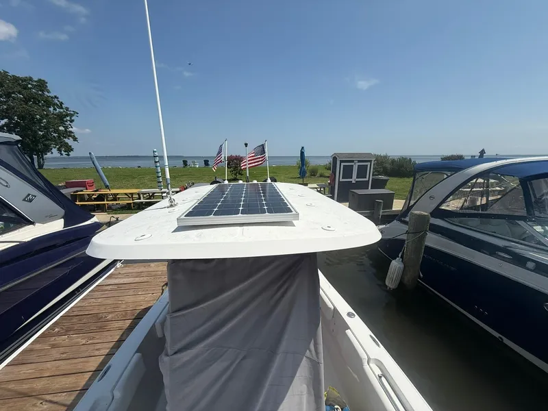 Slide: The Image of 2017 Sea Hunt Ultra 234 boat with solar panel docked by the water. - 7