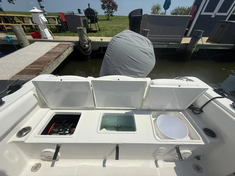 Slide: The Image of 2017 Sea Hunt Ultra 234 boat with open storage compartments at dockside. - 8