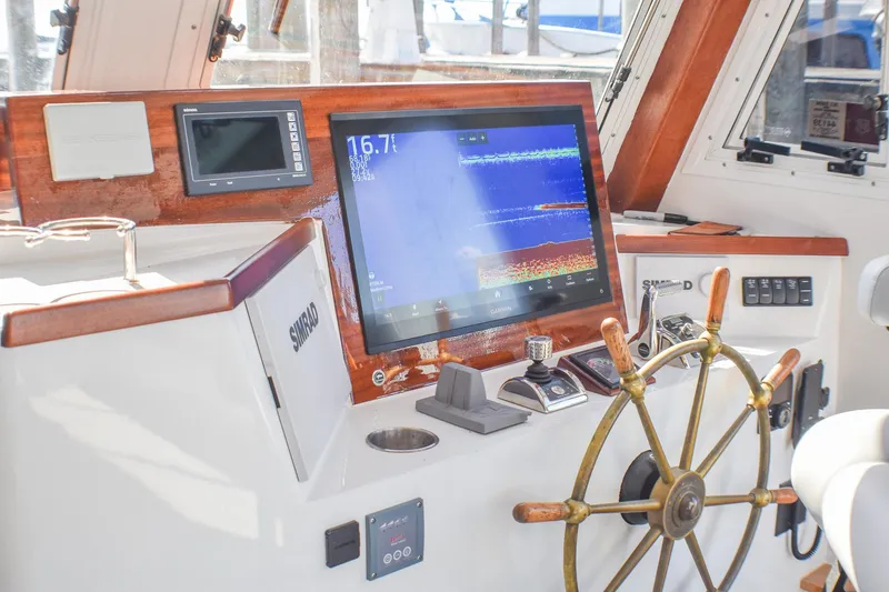 Slide: The Image of 2021 Mussel Ridge Downeast boat helm with navigation screens and wooden steering wheel. - 10
