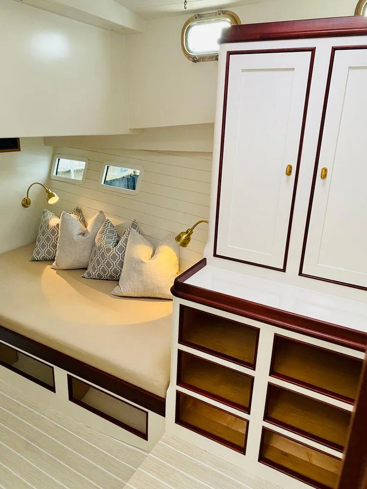 Slide: The Image of 2021 Mussel Ridge downeast boat interior with cozy seating, pillows, and elegant cabinetry. - 13