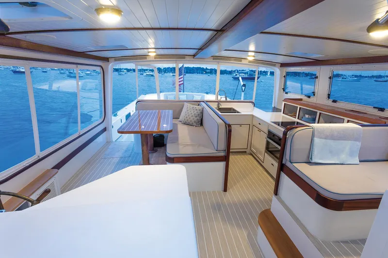 Slide: The Image of Elegant 2021 Mussel Ridge downeast boat interior with seating, table, and scenic ocean view. - 17