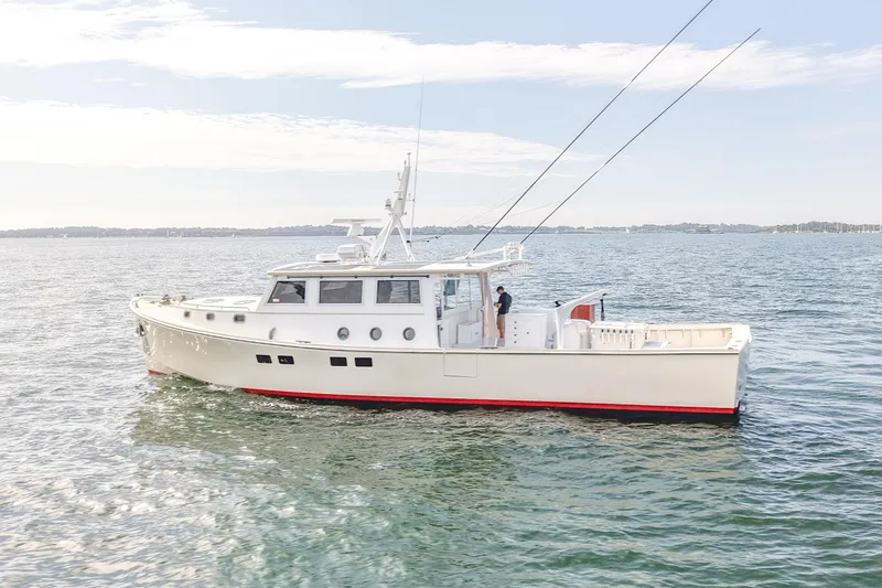 Slide: The Image of 2021 Mussel Ridge Downeast boat cruising on calm waters under a clear sky. - 3
