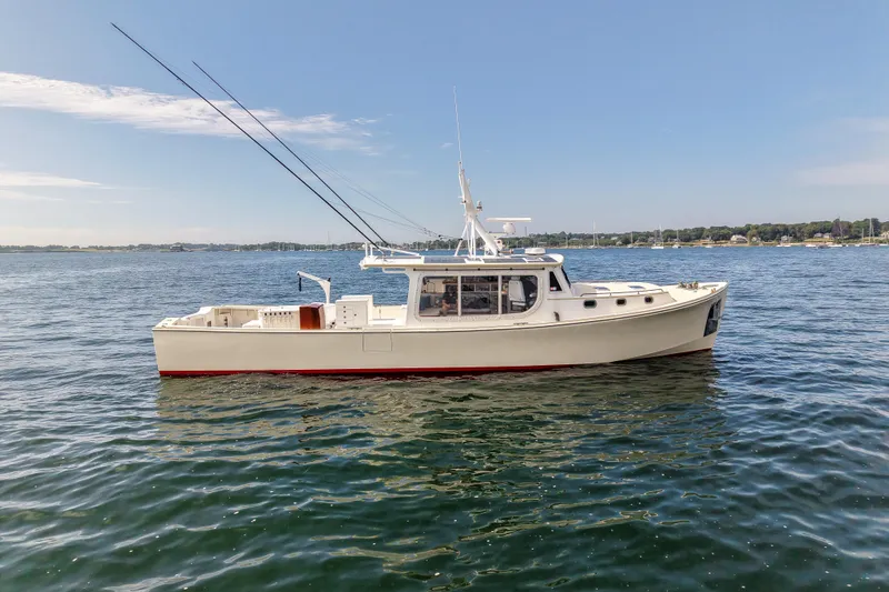Slide: The Image of 2021 Mussel Ridge Downeast boat on calm water under clear sky. - 4