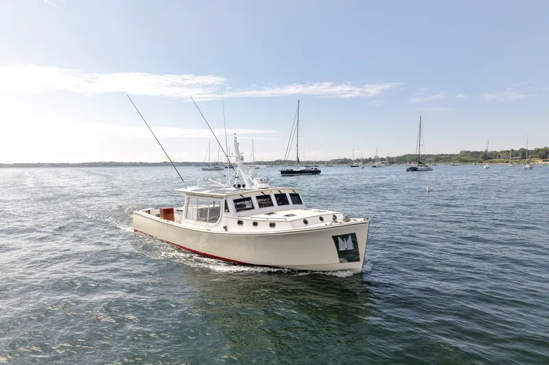Slide: The Image of 2021 Mussel Ridge Downeast boat cruising on a calm sea under a clear sky. - 6