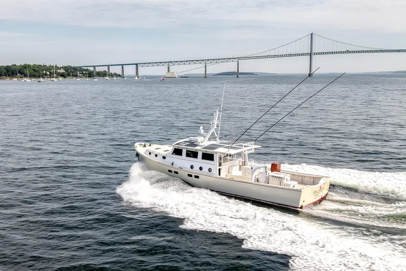 Slide: The Image of 2021 Mussel Ridge Downeast boat cruising near a large bridge on a sunny day. - 8