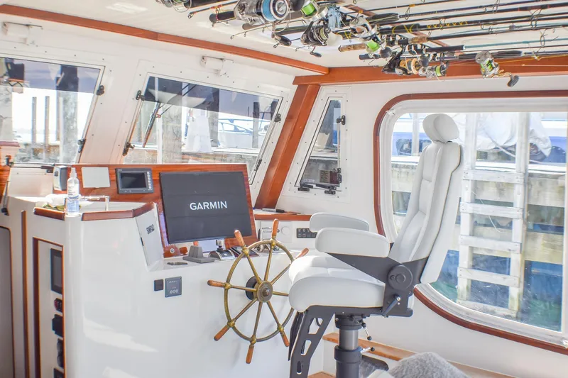 Slide: The Image of 2021 Mussel Ridge Downeast boat interior with Garmin navigation, fishing rods, and captain's chair. - 9