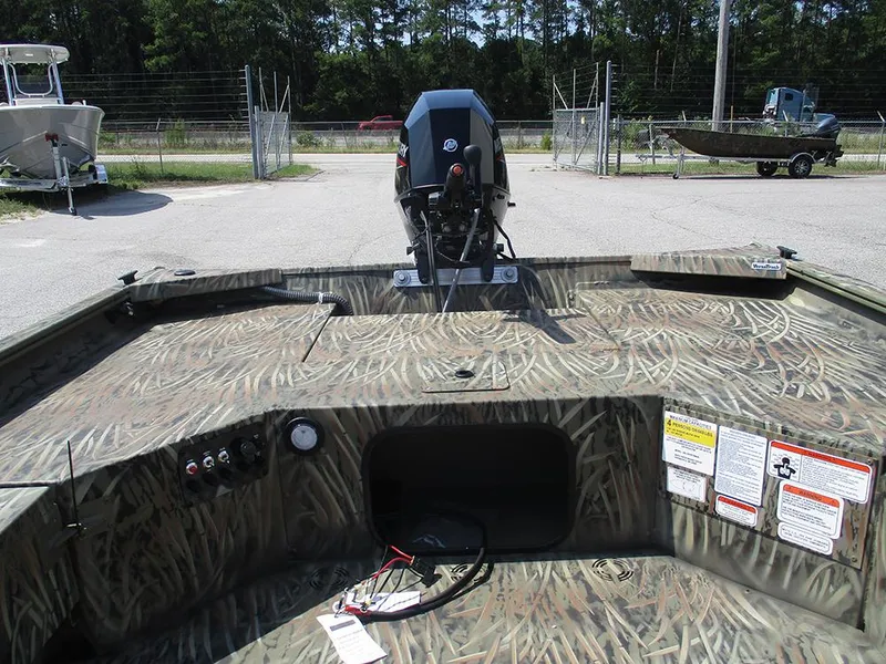 Slide: The Image of 2026 Tracker Grizzly 1654 T Sportsman boat with camouflage design and outboard motor. - 10