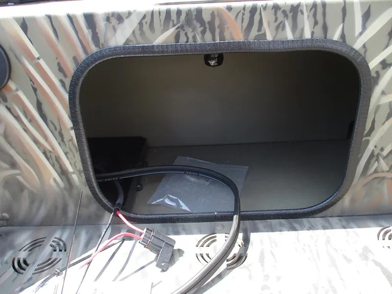 Slide: The Image of Open storage compartment in 2026 Tracker Grizzly 1654 T Sportsman boat with wiring visible. - 11