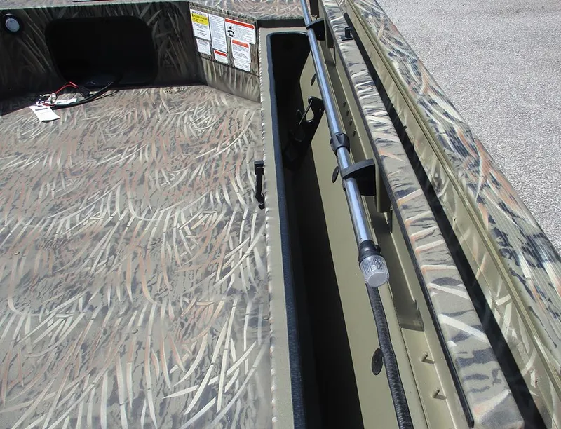 Slide: The Image of 2026 Tracker Grizzly 1654 T Sportsman boat interior with camouflage pattern and rod holder. - 16
