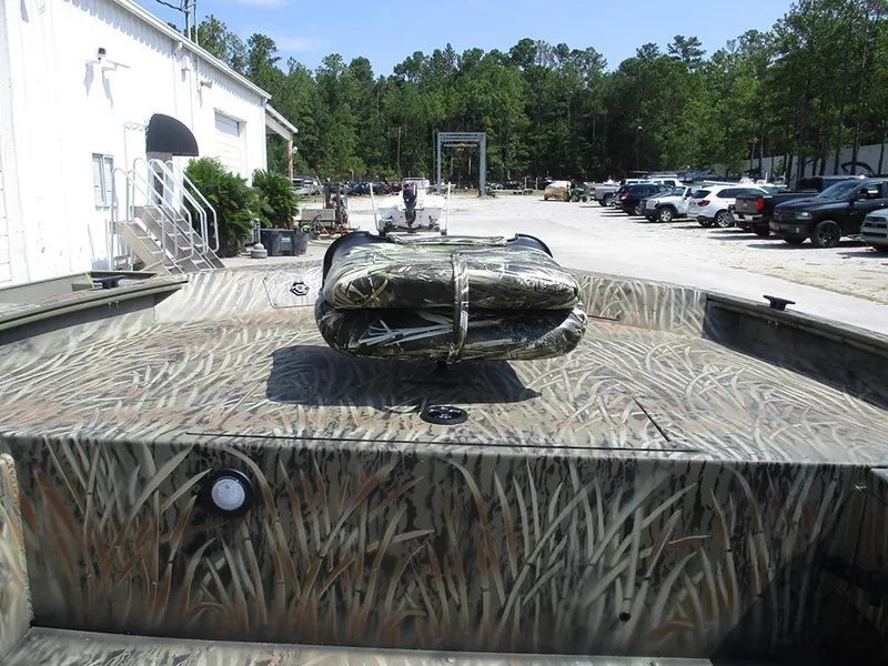 Slide: The Image of 2026 Tracker Grizzly 1654 T Sportsman boat with camouflage design in outdoor setting. - 17