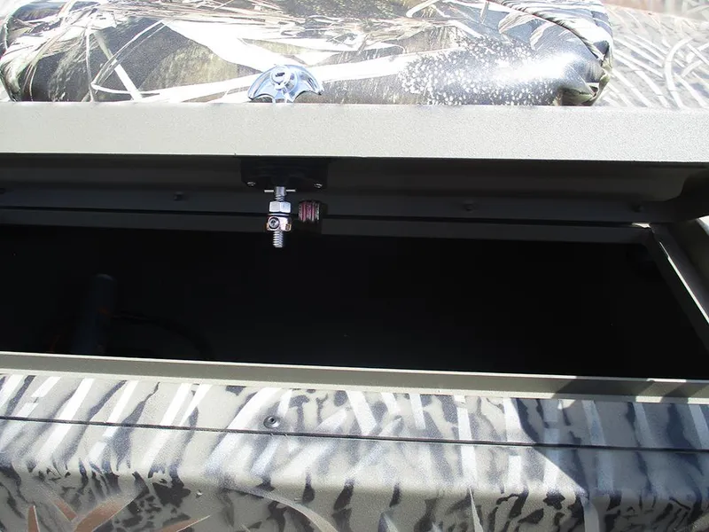Slide: The Image of Open storage compartment of 2026 Tracker Grizzly 1654 T Sportsman boat with camo design. - 18