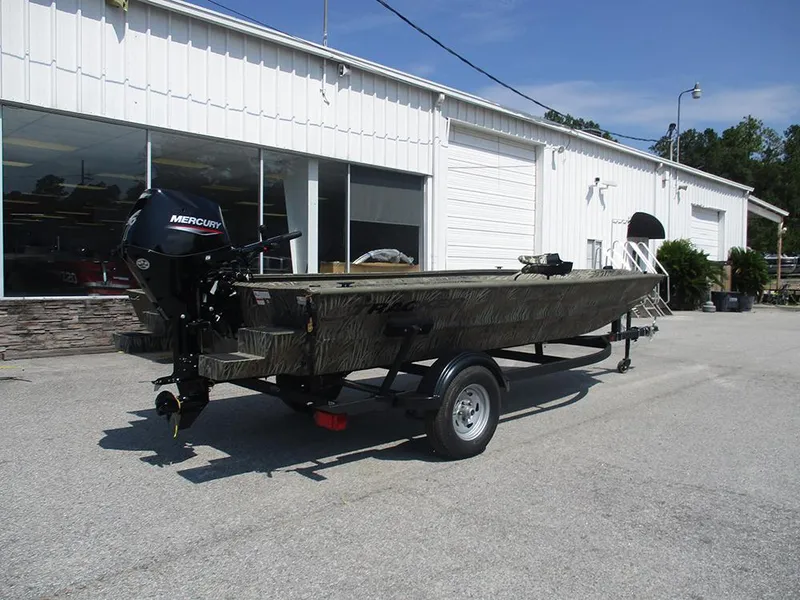 Slide: The Image of 2026 Tracker Grizzly 1654 T Sportsman boat on trailer, parked outside a white building. - 7