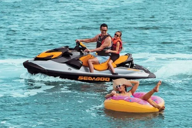 Slide: The Image of Manufacturer Provided Image: 2020 Sea-Doo GTI SE 170 jet ski with two riders on water, person relaxing on inflatable. - 10