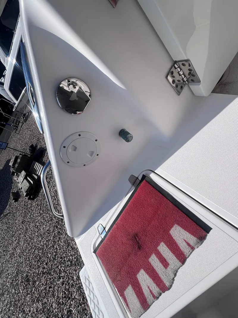 Slide: The Image of 2015 Pursuit OS 345 Offshore boat deck with red mat and metal fixtures. - 11