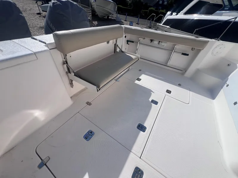 Slide: The Image of 2015 Pursuit OS 345 Offshore boat interior with foldable seating and storage compartments. - 13