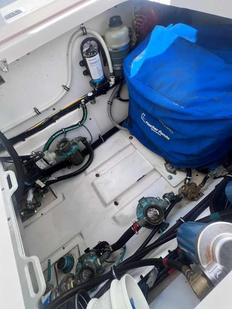 Slide: The Image of Engine compartment of a 2015 Pursuit OS 345 Offshore boat, showing various mechanical components. - 15