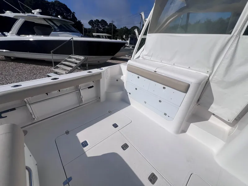 Slide: The Image of 2015 Pursuit OS 345 Offshore boat interior with seating and storage compartments. - 16