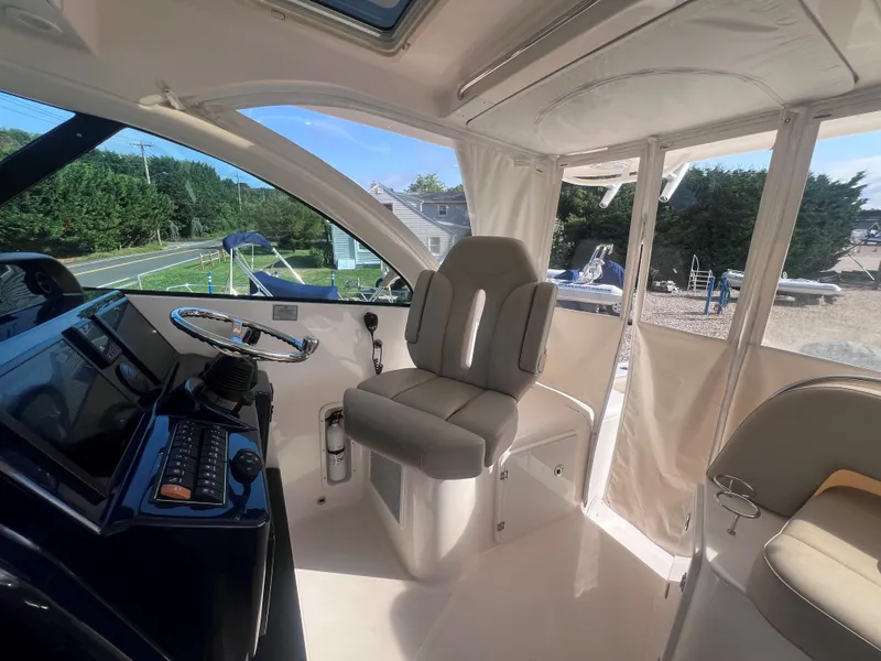 Slide: The Image of Interior of a 2015 Pursuit OS 345 Offshore boat, featuring helm and seating area. - 27