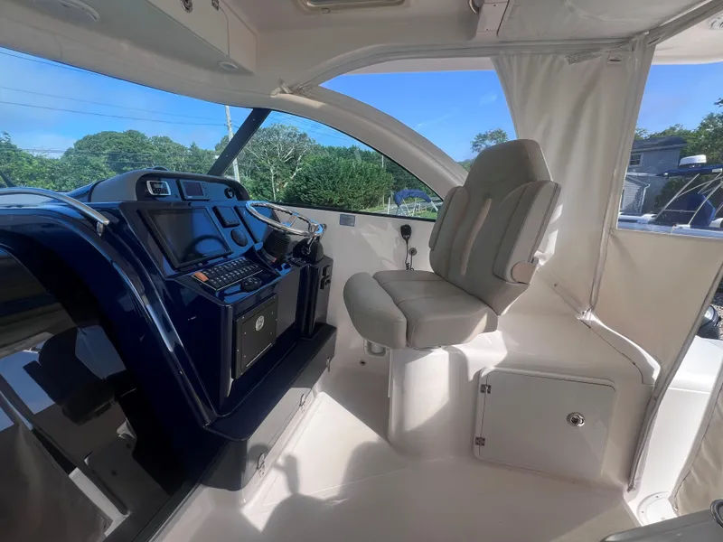 Slide: The Image of 2015 Pursuit OS 345 Offshore boat interior with helm, steering wheel, and captain's chair. - 28
