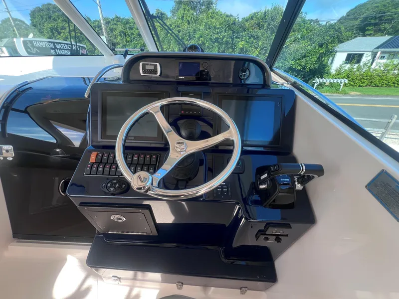 Slide: The Image of 2015 Pursuit OS 345 Offshore boat helm with steering wheel and control panel. - 30