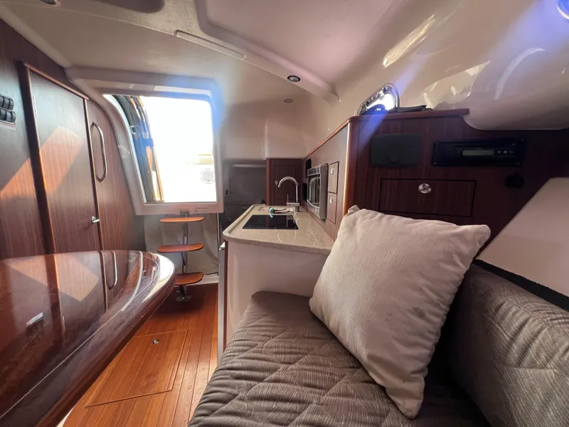 Slide: The Image of 2015 Pursuit OS 345 Offshore cabin interior with modern kitchen and seating area. - 31