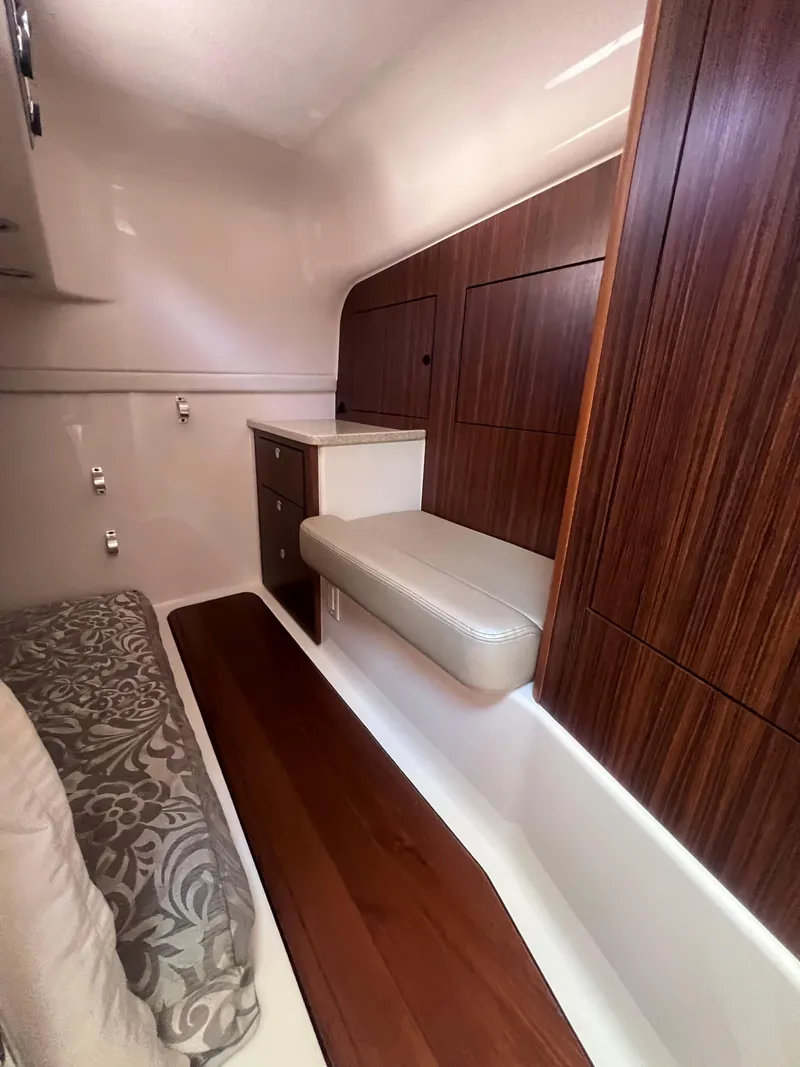 Slide: The Image of 2015 Pursuit OS 345 Offshore cabin interior with wood paneling and cushioned seating. - 34