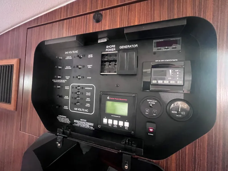 Slide: The Image of Electrical control panel on a 2015 Pursuit OS 345 Offshore boat, featuring various switches and gauges. - 39