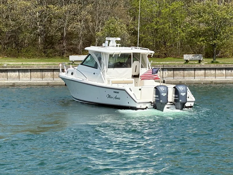 Slide: The Image of 2015 Pursuit OS 345 Offshore boat cruising on a calm waterway with American flag. - 4