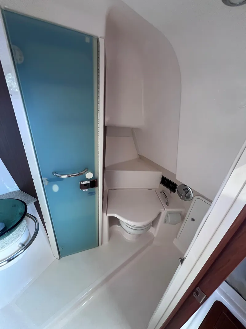Slide: The Image of 2015 Pursuit OS 345 Offshore boat bathroom with modern fixtures and blue glass door. - 41