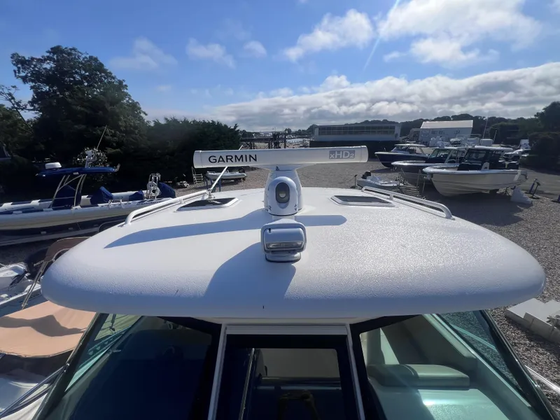 Slide: The Image of 2015 Pursuit OS 345 Offshore boat with Garmin radar, docked under a clear sky. - 42
