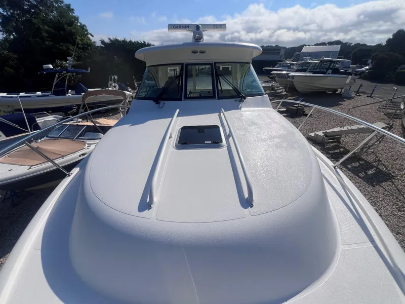 Slide: The Image of 2015 Pursuit OS 345 Offshore boat on display, featuring a sleek white deck and windshield. - 44