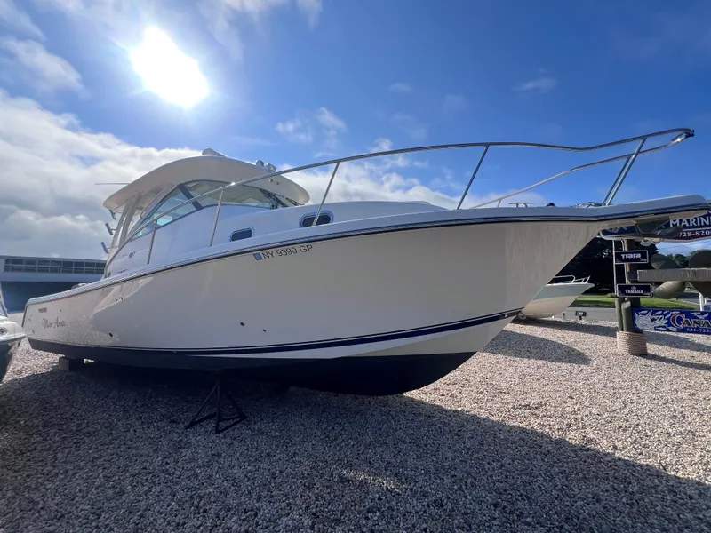 Slide: The Image of 2015 Pursuit OS 345 Offshore boat on gravel under a bright sky. - 49