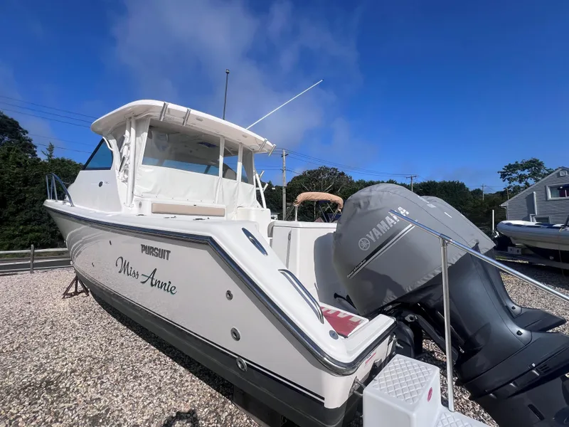 Slide: The Image of 2015 Pursuit OS 345 Offshore boat with Yamaha engine, named "Miss Annie," on gravel lot. - 7
