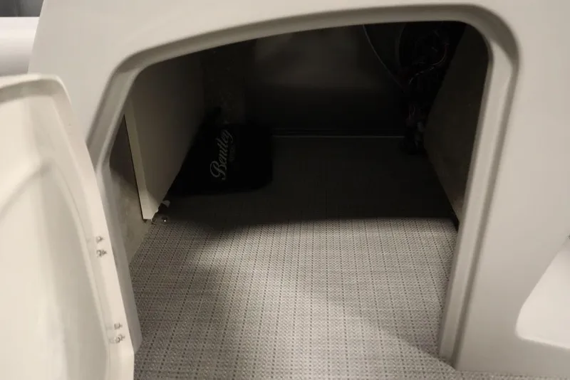 Slide: The Image of Storage compartment in 2025 Bentley Pontoons 243 Navigator Tri-toon, featuring carpeted interior. - 15