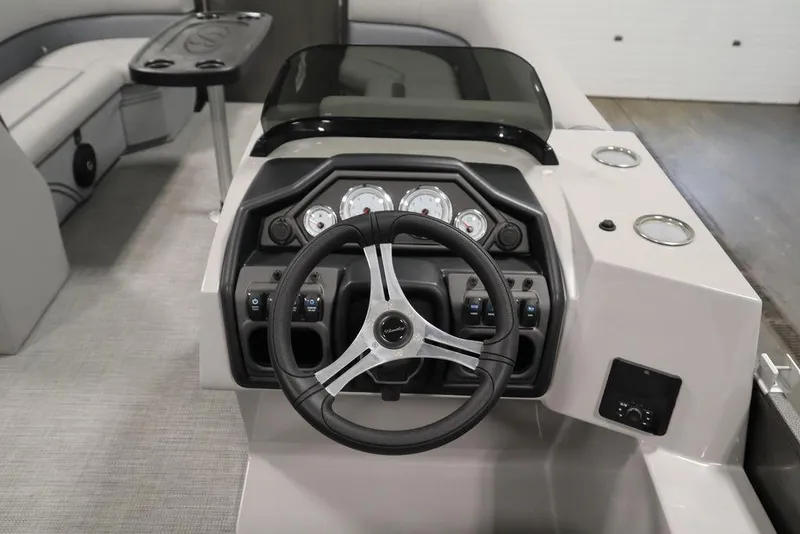 Slide: The Image of 2025 Bentley Pontoons 243 Navigator Tri-toon dashboard with steering wheel and gauges. - 19