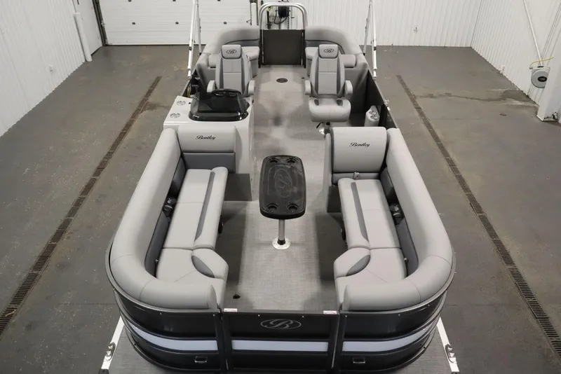 Slide: The Image of 2025 Bentley Pontoons 243 Navigator Tri-toon with spacious seating and sleek design in a showroom. - 9