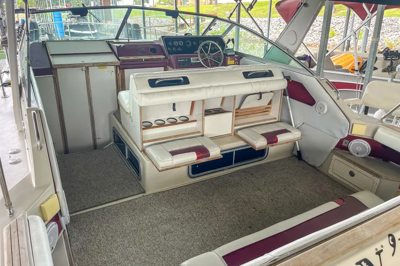 Slide: The Image of 1987 Sea Ray 300 Sundancer interior with helm, seating, and carpeted flooring. - 11