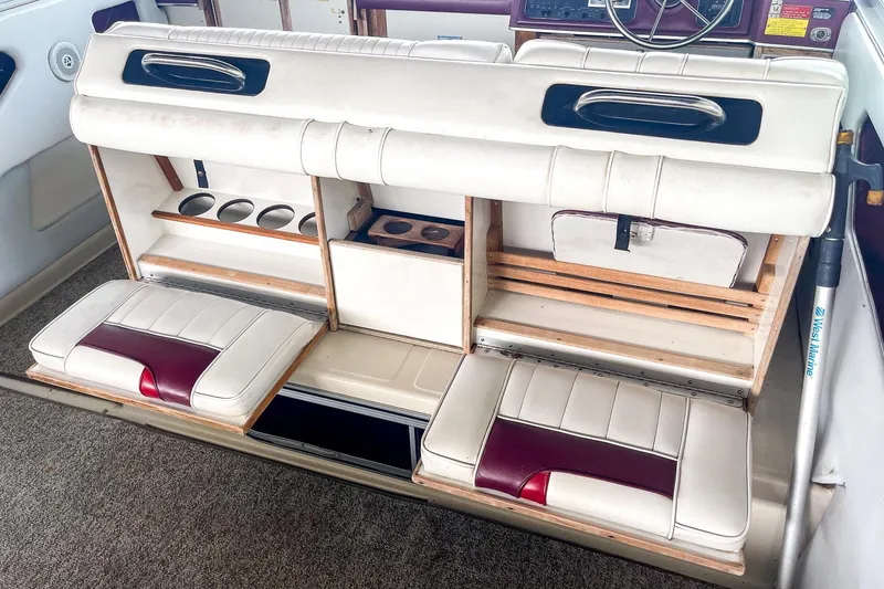Slide: The Image of 1987 Sea Ray 300 Sundancer interior with white and maroon seating, storage compartments. - 12