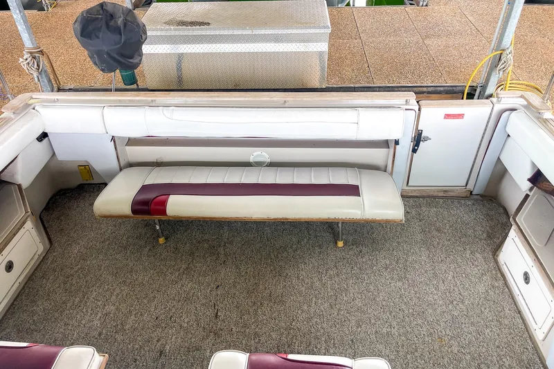 Slide: The Image of 1987 Sea Ray 300 Sundancer interior with cushioned seating and carpeted flooring. - 15